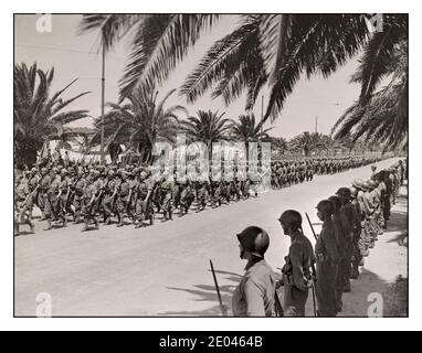 TUNIS 1943 2. Weltkrieg Nordafrika Siegespropaganda Foto Tunis, Tunesien Französische Soldaten marschieren in der alliierten Siegesparade entlang der Avenue Gambetta. Amerikanische Soldaten, die bei der Parade stehen, ruhen im Vordergrund. Usa. Informationen zum Kriegsbüro. Usa. Armee. Signalkorps. 1943 Mai 20. - Weltkrieg, 1939-1945--Militärpersonal--Französisch--Tunesien--Tunis - Militärparaden und Zeremonien--Tunesien--Tunis--1940-1950. Achse aus Nordafrika ausgeworfen 1943 Foto von Jack Collins für das US Army Signal Corps. Stockfoto