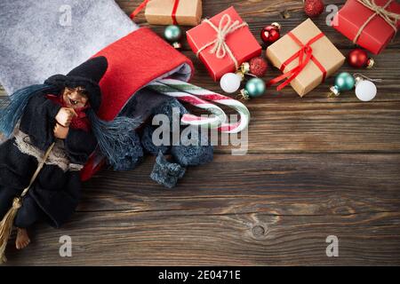 Die Befana mit süßer Kohle und Süßigkeiten auf Holzhintergrund. Italienische Dreikönigstag Tradition. Stockfoto