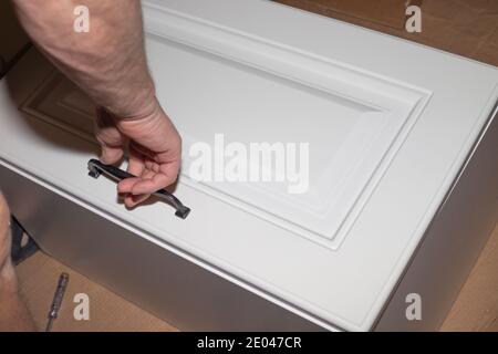 Montage von Holzmöbeln, Oberschrank eines Küchengarnitur. Zimmermannservice. Stockfoto