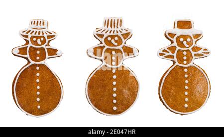 Set von süßen Lebkuchen in Schneemann-Form isoliert auf weißem Hintergrund. Nahaufnahme von drei niedlichen Weihnachtsplätzchen mit Glasur dekoriert. Gebackenes Kinderspielzeug. Stockfoto