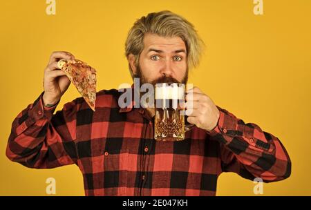 italienische Küche. italien ist hier. Kerl in der Bar Bier trinken und Pizza essen. Prost. Glas Bier und Pizza. Fußball im Fernsehen. Fastfood. Glücklicher bärtiger Mann mit Bier und Pizza. Stockfoto