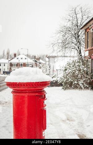 Red Royal Mail UK Briefkasten in verschneite Straßenszene Stockfoto