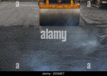 Entwicklung der städtischen Infrastruktur. Asphalt Straßenwalze mit schweren Vibrationswalze Walze Presse neuen heißen Asphalt. Neue Straßenbauarbeiten. Asphaltstraße Stockfoto