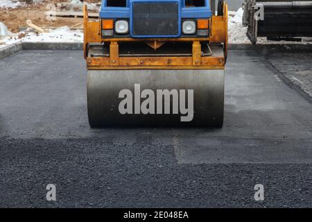 Entwicklung der städtischen Infrastruktur. Asphalt Straßenwalze mit schweren Vibrationswalze Walze Presse neuen heißen Asphalt. Neue Straßenbauarbeiten. Asphaltstraße Stockfoto