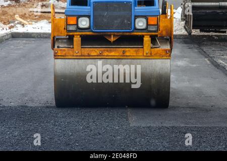 Entwicklung der städtischen Infrastruktur. Asphalt Straßenwalze mit schweren Vibrationswalze Walze Presse neuen heißen Asphalt. Neue Straßenbauarbeiten. Asphaltstraße Stockfoto