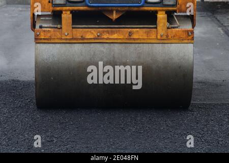 Entwicklung der städtischen Infrastruktur. Asphalt Straßenwalze mit schweren Vibrationswalze Walze Presse neuen heißen Asphalt. Neue Straßenbauarbeiten. Asphaltstraße Stockfoto