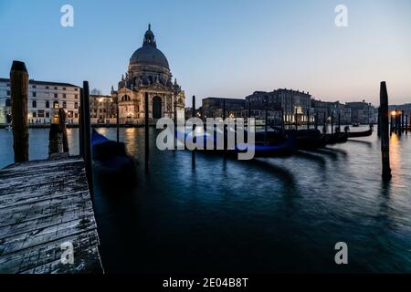 Venezianische Gondel bei Sonnenuntergang, Gondeln in Venedig mit Santa Maria della Salute Basilika im Hintergrund, Italien Stockfoto