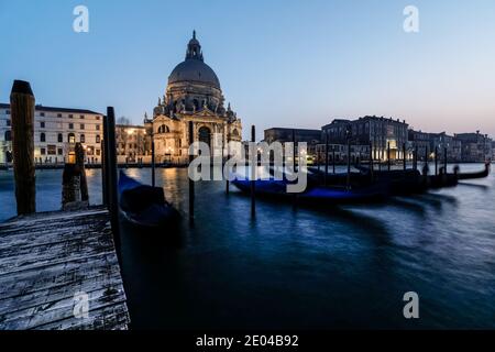 Venezianische Gondel bei Sonnenuntergang, Gondeln in Venedig mit Santa Maria della Salute Basilika im Hintergrund, Italien Stockfoto