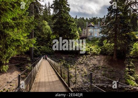 Die Eisenbrücke mit dem Haus im Hintergrund, Cragside, Northumberland zu sehen. Stockfoto