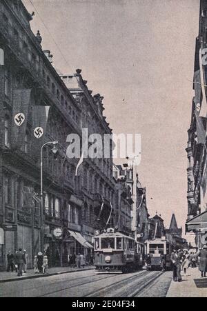 PRAG, PROTEKTORAT BÖHMEN UND MÄHREN - 1942: Unbekannte Straße in Prag. Nazi Swastika Flaggen auf Gebäude. Stockfoto