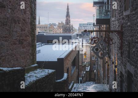 Ein Blick von Advocate's Close Out auf die Princes Street in Edinburgh und das Scott Monument an einem Dezembermorgen nach einem nächtlichen Schneefall. Stockfoto
