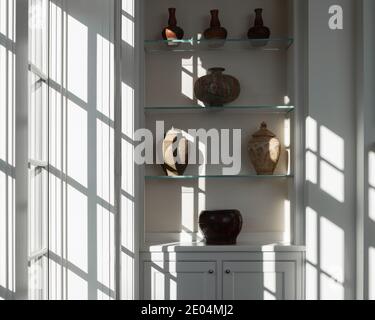Licht aus dem Fenster, das auf antike Töpfersammlung streamt Stockfoto