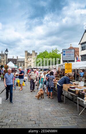 Leute, die Stände am Straßenmarkt in Wells bummelt das historische Bishop's Eye Wahrzeichen in der Ferne, Somerset, England, Großbritannien Stockfoto