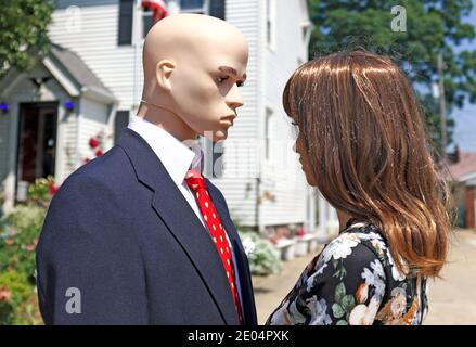 Ein paar Schaufensterpuppen schauen sich liebevoll in die Augen, als er eine rote Valentinstag Krawatte Sport. Stockfoto