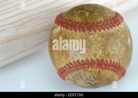 Ein alter und gut gebrauchter Baseball wird aus der Nähe gezeigt, neben einem neuen, Holz Baseballschläger. Stockfoto