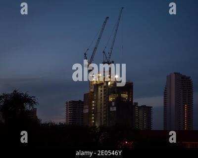 Nachtfoto des Gebäudes im Bau in der Pratamnak Gegend in Pattaya, Thailand. Trotz der Covid-19-Pandemie werden neue Hotels gebaut. Stockfoto