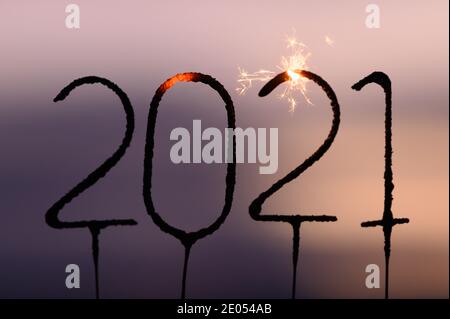 Dresden, Deutschland. Dezember 2020. ABBILDUNG - vier Wunderkerzen in der Zahlenfolge 2021 brennen in der Dämmerung (posierte Szene). Quelle: Sebastian Kahnert/dpa-Zentralbild/dpa/Alamy Live News Stockfoto