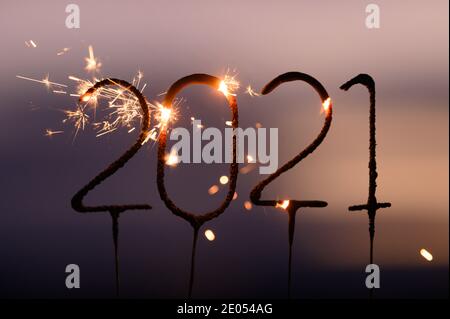 Dresden, Deutschland. Dezember 2020. ABBILDUNG - vier Wunderkerzen in der Zahlenfolge 2021 brennen in der Dämmerung (posierte Szene). Quelle: Sebastian Kahnert/dpa-Zentralbild/dpa/Alamy Live News Stockfoto