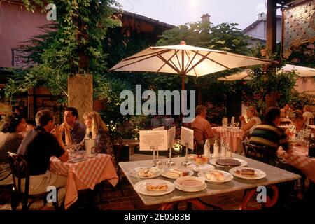 Kleine Gruppe von Männern und Frauen sitzen und trinken im rustikalen Georges Blanc Restaurant in Vonnas, in der französischen Provinz Bresse, Frankreich. Stockfoto