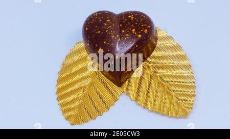 Nahaufnahme von Schokoladenbonbons auf goldenen Blättern Stockfoto