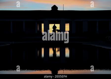 Sandbanks, Großbritannien. Dezember 2020. Ein Hundespaziergang geht zum Strand bei Sonnenaufgang in Sandbanks in Poole, Dorset. Kredit: Richard Crease/Alamy Live Nachrichten Stockfoto