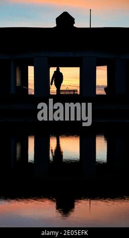 Sandbanks, Großbritannien. Dezember 2020. Ein Hundespaziergang geht zum Strand bei Sonnenaufgang in Sandbanks in Poole, Dorset. Kredit: Richard Crease/Alamy Live Nachrichten Stockfoto