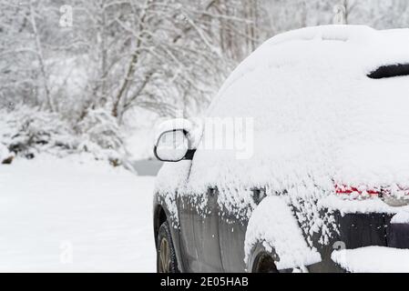 suv Car ist alle mit Schnee bedeckt am Wintermorgen auf dem Land. Konzept des Fahrens im Winter mit Schnee auf der Straße. Stockfoto