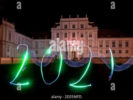 Oranienburg, Deutschland. Dezember 2020. Eine Frau hat das Jahr 2021 mit einer Taschenlampe vor Schloss Oranienburg (Brandenburg) gezeichnet. (Langzeitbelichtung) Kredit: Paul Zinken/dpa/Alamy Live Nachrichten Stockfoto