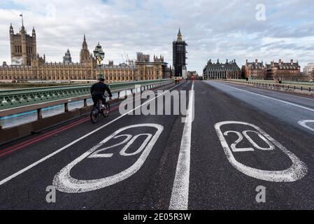 London, Großbritannien. 30 Dezember 2020. Die Houses of Parliament stehen hinter einem Paar von 20 Meilen pro Stunde Tempolimit-Schildern auf der Straße auf der Westminster Bridge, die zusammen das Jahr 2020 zeigen. Das Jahr 2020 neigt sich dem Ende zu und die Abgeordneten werden heute das Handelsabkommen zwischen Großbritannien und der EU im Parlament ratifizieren. Gleichzeitig versucht die britische Regierung, die Auswirkungen der Rekordwerte von Coronavirus-Fällen zu bekämpfen, die eine Erhöhung der nationalen Alarmstufen erfordern könnten. Kredit: Stephen Chung / Alamy Live Nachrichten Stockfoto