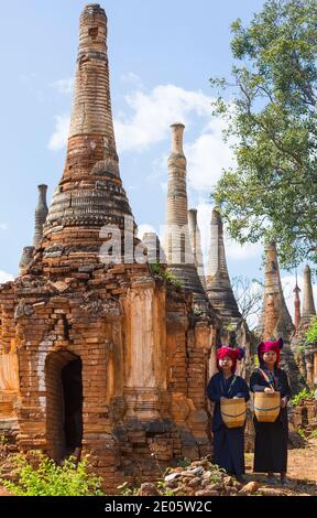 Junge Pa O Damen, die Körbe tragen, wandern im Februar um Stupas im Shwe Indein Pagode Complex, Shan State, Inle Lake, Myanmar (Burma), Asien Stockfoto