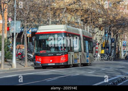 Barcelona, Spanien: Dezember 30 2020: Bus hinter Basicila und der Expiatory Church of the Holy Family, bekannt als Sagrada Familia bei Sonnenuntergang in COVID Zeit. Stockfoto