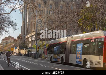 Barcelona, Spanien: Dezember 30 2020: Bus hinter Basicila und der Expiatory Church of the Holy Family, bekannt als Sagrada Familia bei Sonnenuntergang in COVID Zeit. Stockfoto