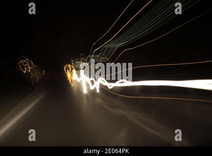 Der Fahrer sieht durch die Windschutzscheibe Scheinwerfer, verzerrte, verschwommene Sicht durch Drogen- oder Alkoholvergiftung bei Nachtfahrten Stockfoto