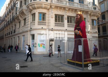 Malaga, Spanien. Dezember 2020. Eine riesige Figur, die Melchior, einen der drei Weisen, darstellt, ist auf dem Platz Plaza Felix Saenz zu sehen, wenn Menschen auf der Straße spazieren.das Rathaus von Málaga hat in Straßen und Plätzen riesige Figuren der drei Weisen aufgestellt, die Kinder und Familien genießen und besuchen können. Ein paar Tage vor der Epiphanie Parade der drei Könige. Die Zahlen messen 5 Meter und sind mit Schutzschirmen isoliert, um die Coronavirus-Krankheit zu verhindern. Kredit: SOPA Images Limited/Alamy Live Nachrichten Stockfoto