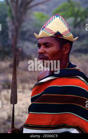 Porträt des Tribal Antrandroy Krieger oder Stammesmann tragen traditionelle Malagasy Lamba, Strohhut & Tragen eines Speers in Süd-Madagaskar Stockfoto