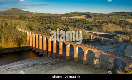 Melrose, Scottish Borders. 30. Dezember 2020 Leaderfoot Viadukt, River Tweed bei Melrose, Scottish Borders. Schottland. UK Winter Sonnenschein Wetter. Ein Blick auf das Leaderfoot Viadukt, das den Fluss Tweed überspannt, zusammen mit zwei anderen Fußgängerbrücken und der A68. Das Leaderfoot Viadukt, auch bekannt als Drygrange Viadukt, ist ein Eisenbahnviadukt über den Fluss Tweed bei Melrose in der schottischen Grenze. Das Viadukt wurde am 16. November 1863 eröffnet, um die Berwickshire Railway, Credit Phil Wilkinson / Alamy Live News zu tragen Stockfoto