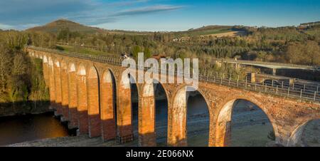 Melrose, Scottish Borders. 30. Dezember 2020 Leaderfoot Viadukt, River Tweed bei Melrose, Scottish Borders. Schottland. UK Winter Sonnenschein Wetter. Ein Blick auf das Leaderfoot Viadukt, das den Fluss Tweed überspannt, zusammen mit zwei anderen Fußgängerbrücken und der A68. Das Leaderfoot Viadukt, auch bekannt als Drygrange Viadukt, ist ein Eisenbahnviadukt über den Fluss Tweed bei Melrose in der schottischen Grenze. Das Viadukt wurde am 16. November 1863 eröffnet, um die Berwickshire Railway, Credit Phil Wilkinson / Alamy Live News zu tragen Stockfoto