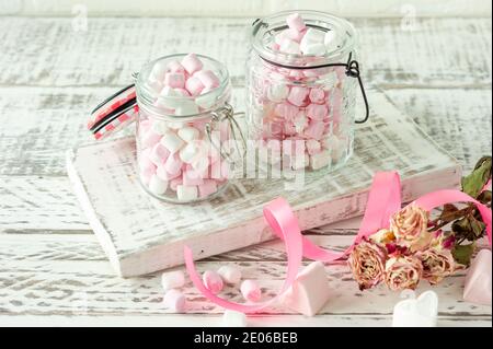 Weiße und rosa Marshmallows zum Braten und heiße Schokolade in Schüsseln, Nahaufnahme. Winter Food Hintergrundkonzept Stockfoto