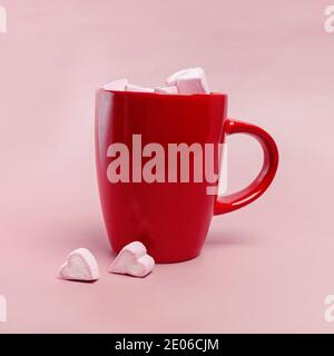 Rote Tasse mit Marshmallows in Form von Herzen Stockfoto