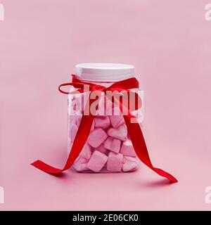 Glas mit herzförmigen rosa Marshmallows Stockfoto
