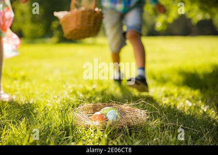 Niedliche Jungen und Mädchen feiern Ostern, Suche und Essen Schokoladeneier. Glücklicher Familienurlaub. Glückliche Kinder lachen, lächeln und Spaß haben. Stockfoto