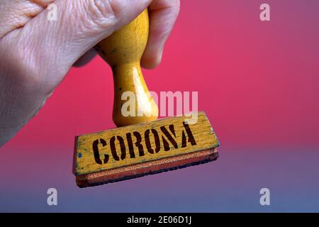 Deutschland. Dezember 2020. Ein alter Holzstempel mit Stempelflecken mit der Aufschrift 'Corona'. Foto mit Komposition vor neutralem Hintergrund. Quelle: dpa/Alamy Live News Stockfoto