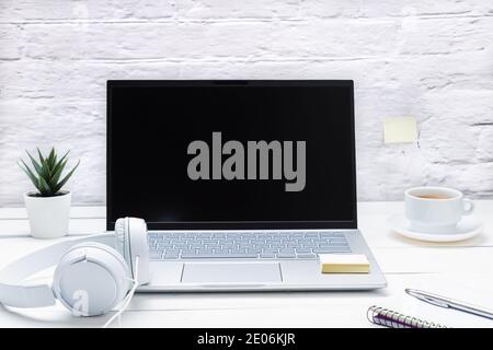Arbeitsplatz mit Notebook, Laptop, Kopfhörer und Kaffee auf weißem Untergrund. Stockfoto