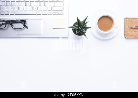 Flaches Lay, Arbeitsplatz mit Laptop, Kaffee und Bürobedarf auf dem Schreibtisch. Mit Kopierbereich. Stockfoto