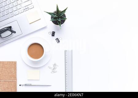 Flaches Lay, Arbeitsplatz mit Laptop, Kaffee und Bürobedarf auf dem Schreibtisch. Mit Kopierbereich. Stockfoto