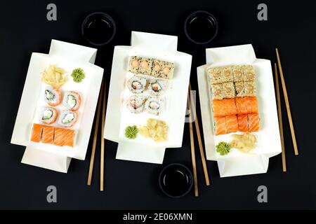 Sushi-Sets in Papier-Take-Away-Behälter mit Essstäbchen und sojasaucen Draufsicht Stockfoto