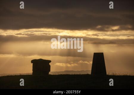 Der trig Point in Silhouette auf dem Hügel von Beath mit Blick auf den Firth of Forth mit einem dramatischen Himmel, Fife, Schottland Stockfoto