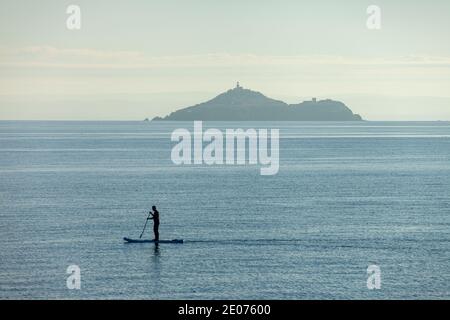 Ein Paddelboarder vor Inchkeith Island vom Kinghorn Harbour aus gesehen, Fife, Schottland. Stockfoto