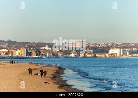 Menschen genießen einen Winterspaziergang am Strand in Kirkcaldy, Fife, Schottland. Stockfoto