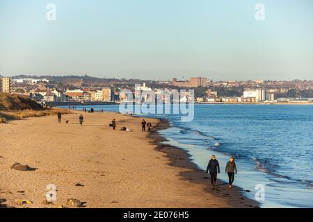 Menschen genießen einen Winterspaziergang am Strand in Kirkcaldy, Fife, Schottland. Stockfoto